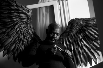 Dramatic portrait of man with angel wings in black and white