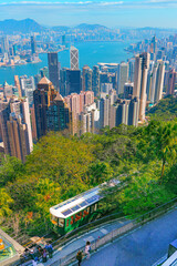The famous green tram on the slope of Victoria Peak in Hong Kong passes, lifting visitors to the observation deck at the top