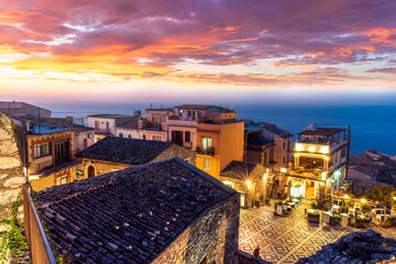Fototapeta premium beautiful travel town view from a mountain to roofs and houses, valley and sea gulf with scenic cloudy sunrise or sunset on background of landscape