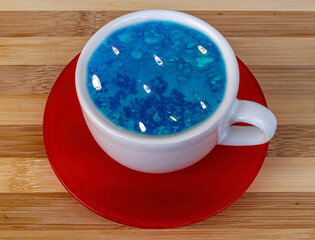 blue or turquoise summer sea with waves and boats in a cup of coffee or tea. Take a travel lake a...
