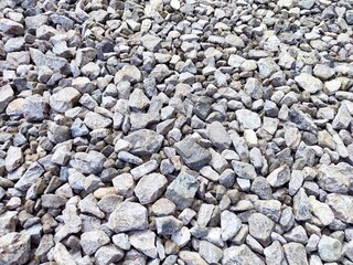 Gravel landscape with various sized stones scattered in a construction site setting during daytime