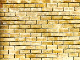 A textured yellow brick wall features a uniform pattern, creating an ideal backdrop for adding text or graphic designs with ample copy space