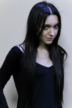 Woman with long dark hair wearing a black top, smiling slightly against a neutral background, Milan, Italy