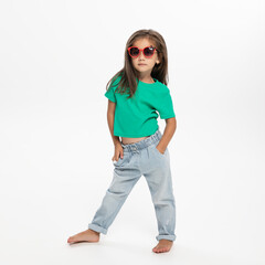 Full length image of fashionable little girl, posing in studio. White background.