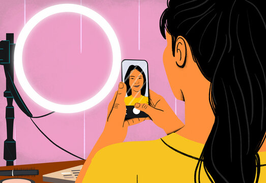 A woman records a vlog with her smartphone, using a ring light for better lighting.