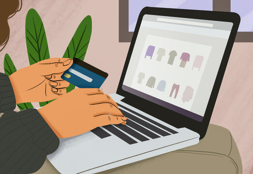 Hands holding a credit card and typing on a laptop with online shopping interface displayed on the screen.
