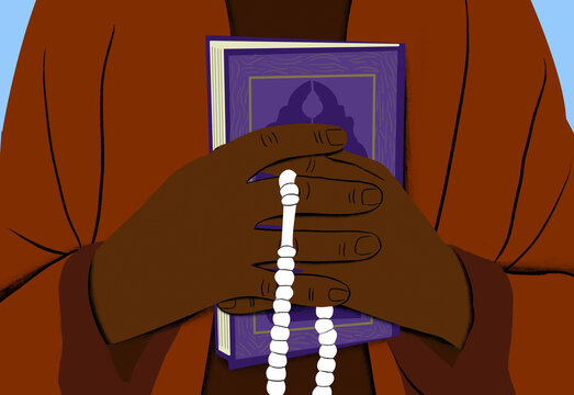 Close-up of a person's hands holding a book and prayer beads with a decorative cover visible.