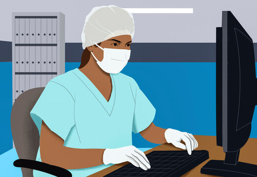 A healthcare professional in scrubs and personal protective equipment works diligently at a computer in a medical office setting.
