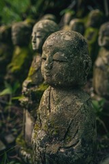 Obraz premium A group of statues sit quietly in a lush green meadow, surrounded by nature