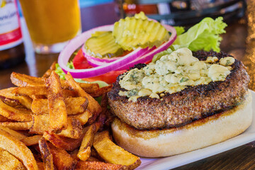 blackened hamburger with broiled blue cheese.  Served with pickle, red onion, lettuce, and tomato