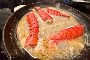 port perry, canada - september 11 2023: lobster roll or tails are being prepared in a pan with boiling water and saus