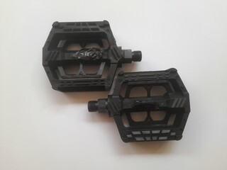 Top view of black bicycle pedals on a white background. background concept of transport, transportation, hobby, lifestyle, accessories, fashion, Wheel, fashionable, cycling, cycle, elegance, steel