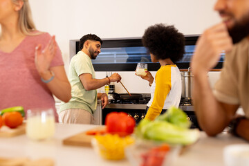 Preparing meal together, diverse friends cooking in kitchen, enjoying fresh ingredients