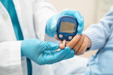 Doctor use digital glucose monitor measure and test stripe for check diabetes from finger blood sugar level.