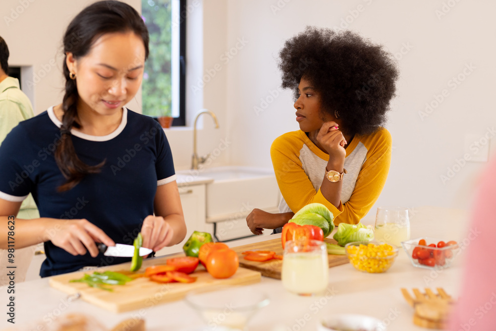 Wall mural Preparing vegetables, diverse friends cooking together in modern kitchen