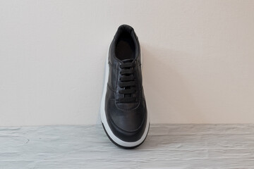 Elegant black eco-leather sneakers with white sole, laced top view