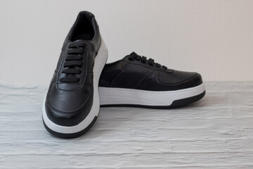 Elegant black eco-leather sneakers with white sole, laced