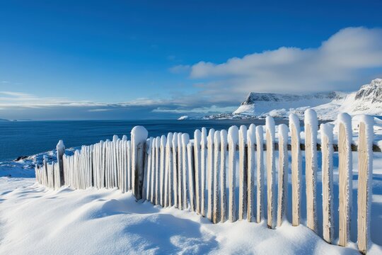 Snow Fence in Hammerfest, Norway. Winter Landscape with Blue Sky and Wooden Fence