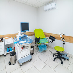 Ultrasound room with medical equipment. The medical examination room features ultrasound equipment, a patient chair, and a clean setup for medical checkups.