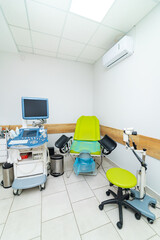 Ultrasound-equipped exam room. A clean medical examination room featuring an ultrasound machine, green examination chair