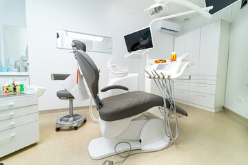 Modern dental office equipped for patient care. A contemporary dental office featuring an adjustable chair, instruments, and a bright environment ready for patient appointments.