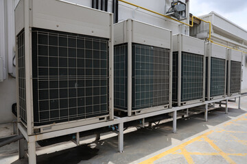 Fototapeta premium Air conditioner compressor installed in old building. Outdoor split wall type air conditioner compressor unit inverter installed on the outside of the building. Air conditioner compressor outdoor unit