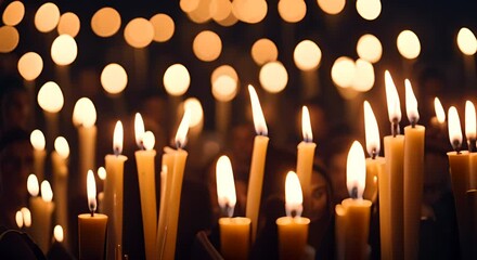 People with candles at a tribute.