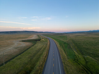 Scenic Alberta Highway Crossing Vast Praries. Sunset Sky