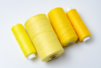 Yellow thread spools on white background.