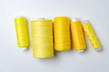 Yellow thread spools on white background.