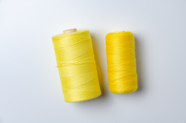 Yellow thread spools on white background.