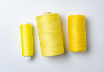 Yellow thread spools on white background.