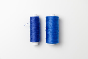 Blue thread spools on white background.