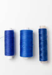 Blue thread spools on white background.