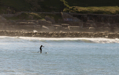Nature background. Seascape with silhouette of a person  in sea from  distance with on surfboard doing standup paddle