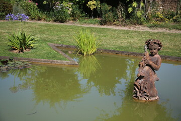 Statue en fonte d'un angelot dans un bassin