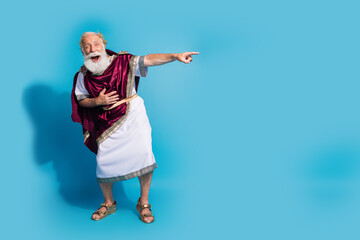 Full size photo of powerful mature man point empty space laughing wear ancient roman emperor tunic...