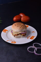 spicy chicken burger with onions pickles and lettuce on a brioche buns