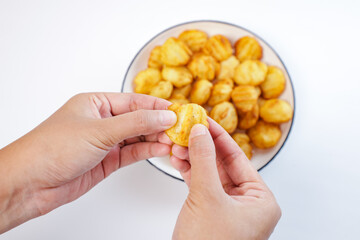 someone's hand holding potato balls. Snack made from potatoes and fried flour on a white background