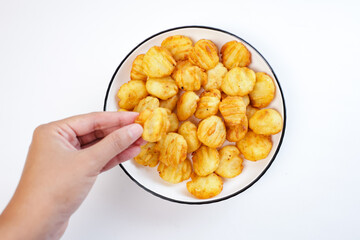 someone's hand holding potato balls. Snack made from potatoes and fried flour on a white background