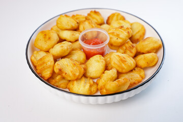 potato balls. Snacks made from fried potatoes and flour accompanied by spicy sauce on a white plate with a white background