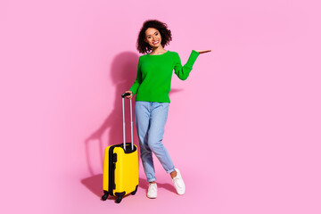 Full size photo of pretty young girl summer vacation suitcase hold empty space wear trendy green outfit isolated on pink color background