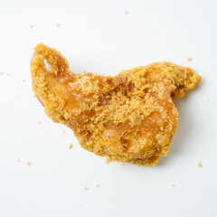 A piece of fried chicken with a lot of seasoning on it