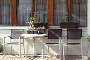 Outdoor seating area with a table and chairs on a patio during summer. No people