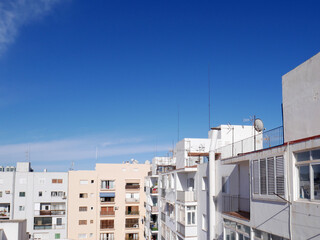 Blue sky, white buildings and sun in Ibiza town
