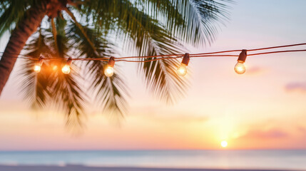 String lights hang from palm trees against a backdrop of a tranquil beach at sunset, creating a serene and picturesque tropical evening scene.