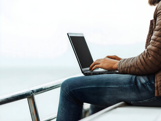A person working on a laptop while sitting on a boat