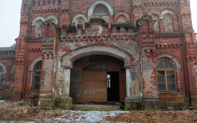 Abandoned brick house with a decayed wall and broken window in a misty area