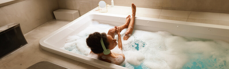 A woman is bathing in a tub of bubbles in the bathroom