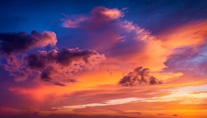 Fototapeta premium Fond d'écran d'un ciel crépusculaire éclatant avec des teintes vives de rouge et d'orange, parsemé de nuages doux.